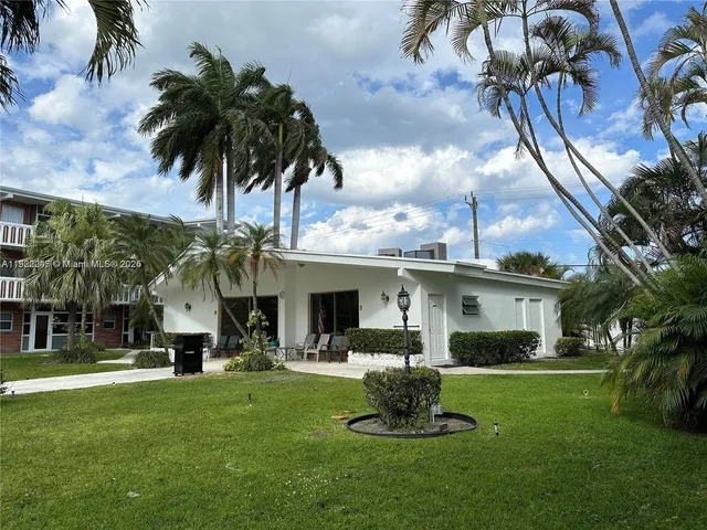 a front view of a house with garden and sitting area
