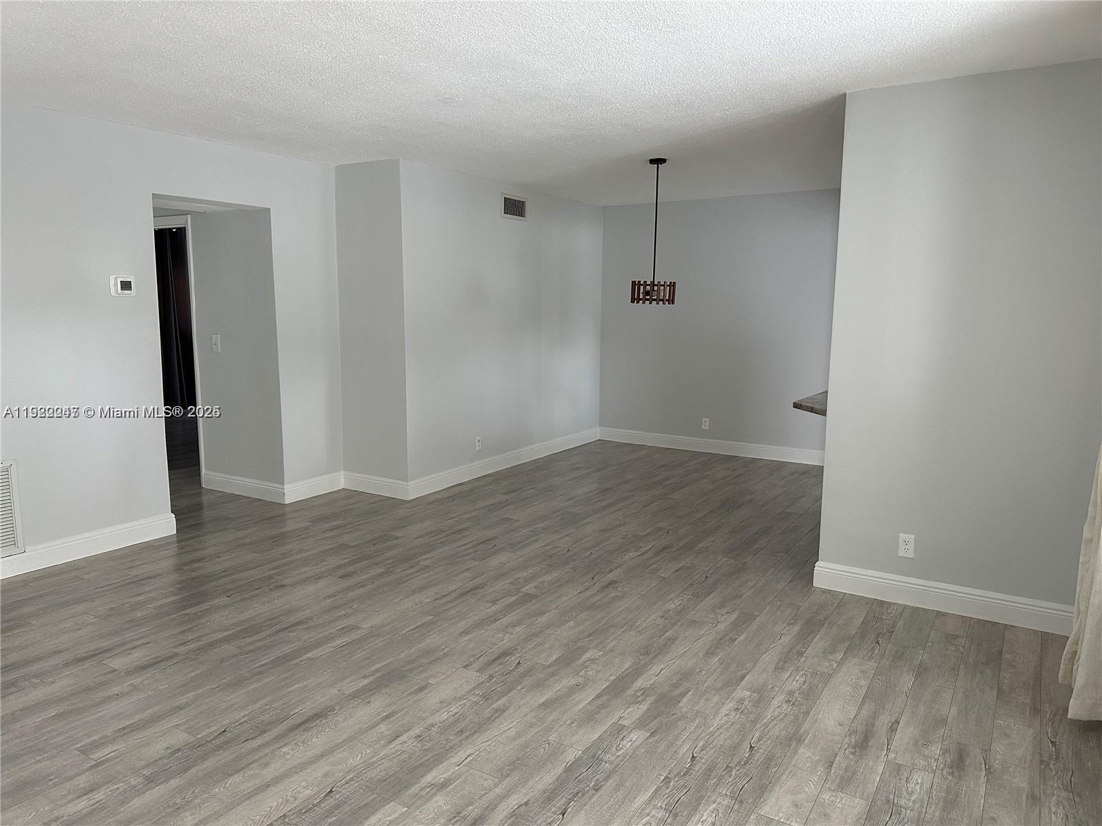 141 Northeast 10th Avenue, Unit 18B Hallandale Beach, FL 33009 - Photo 3 of 15 an empty room with wooden floor and a window