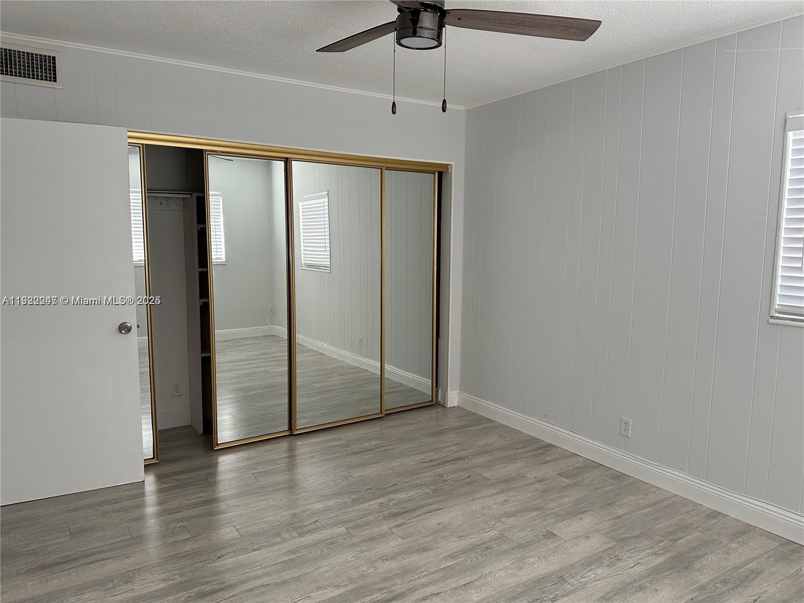 141 Northeast 10th Avenue, Unit 18B Hallandale Beach, FL 33009 - Photo 5 of 15 a view of an empty room with wooden floor