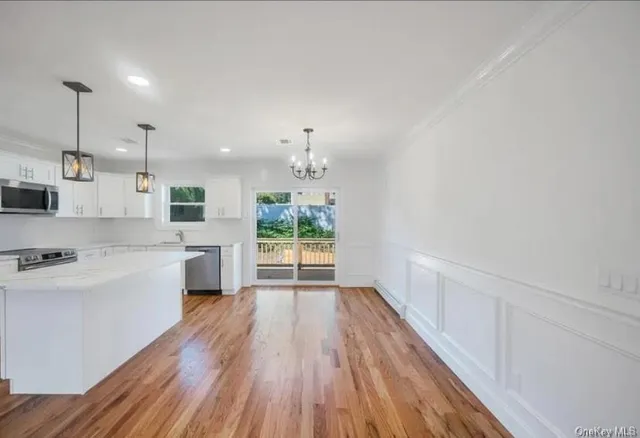 a large kitchen with cabinets wooden floor and stainless steel appliances