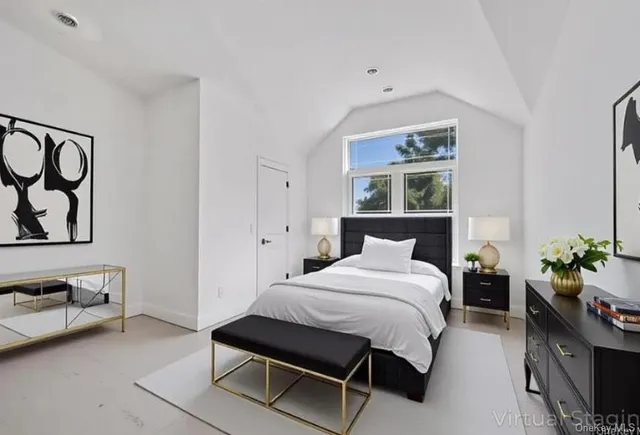 a bedroom with a bed potted plant on dresser and a window