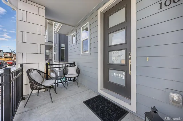 a view of a balcony with chairs and front door