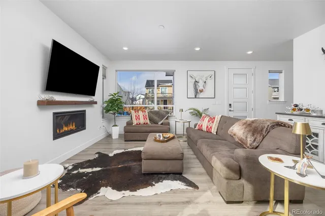 a living room with furniture a flat screen tv and a fireplace