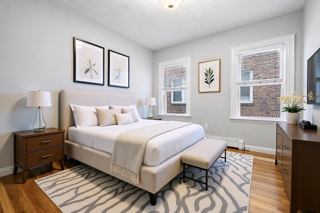 1433 Cambridge Street, Unit 1 Cambridge, MA 02139 - Photo 3 of 14 a bedroom with a bed and wooden floor