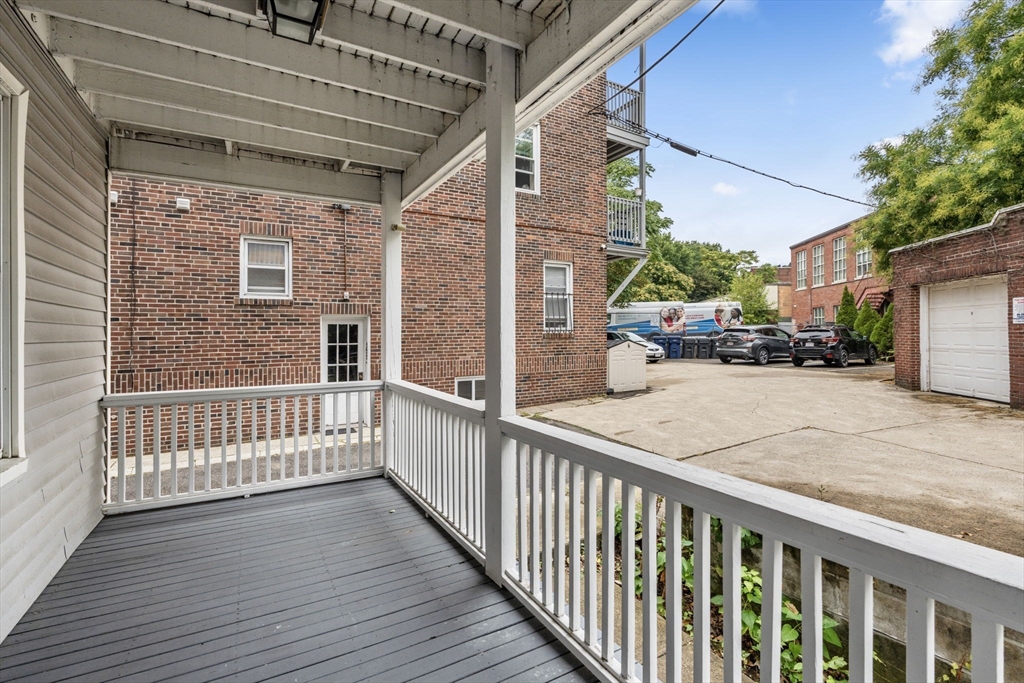 1433 Cambridge Street, Unit 1 Cambridge, MA 02139 - Photo 6 of 14 a view of a porch with wooden floor and iron fence