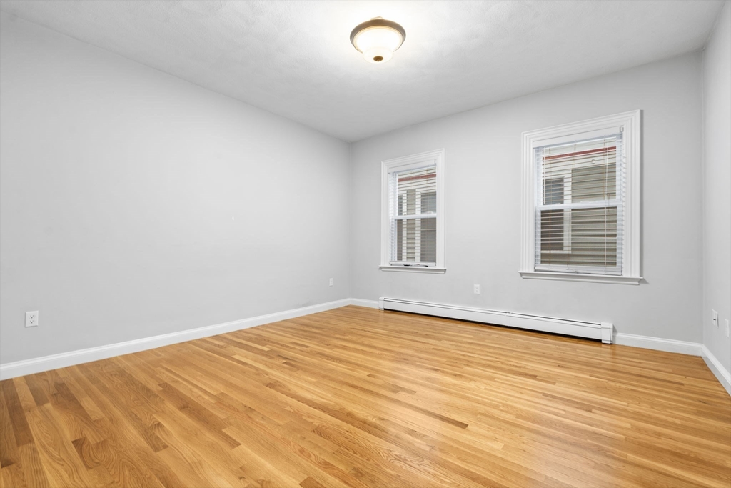 1433 Cambridge Street, Unit 1 Cambridge, MA 02139 - Photo 10 of 14 a view of empty room with wooden floor and fan