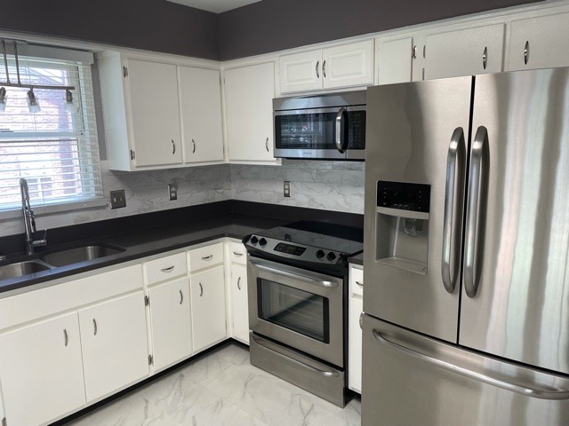 758 Kent Road Nashville, TN 37214 - Photo 5 of 21 a kitchen with white cabinets and stainless steel appliances