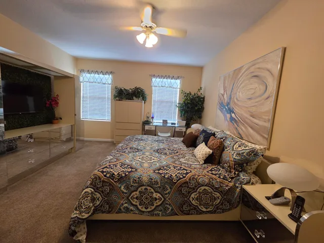 a bedroom with a bed and a flat tv screen on the dresser