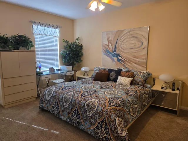 a bedroom with a bed and dresser with mirror