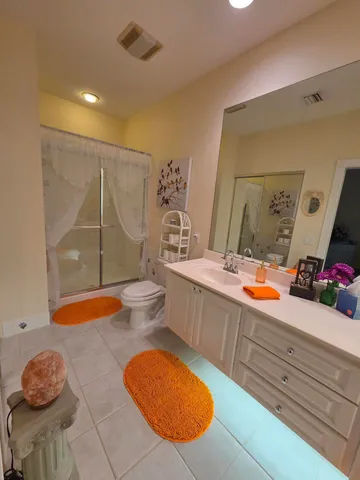 a bathroom with a granite countertop sink mirror vanity and toilet