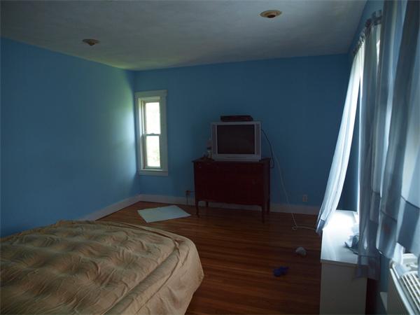 39 Avon Street Somerville, MA 02143 - Photo 12 of 16 a bedroom with a bed and a flat tv screen on the dresser