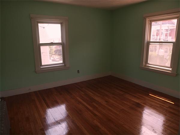 39 Avon Street Somerville, MA 02143 - Photo 10 of 16 an empty room with wooden floor and windows