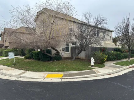 a view of a house with a yard and a large parking space