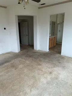 an empty room with closet and windows