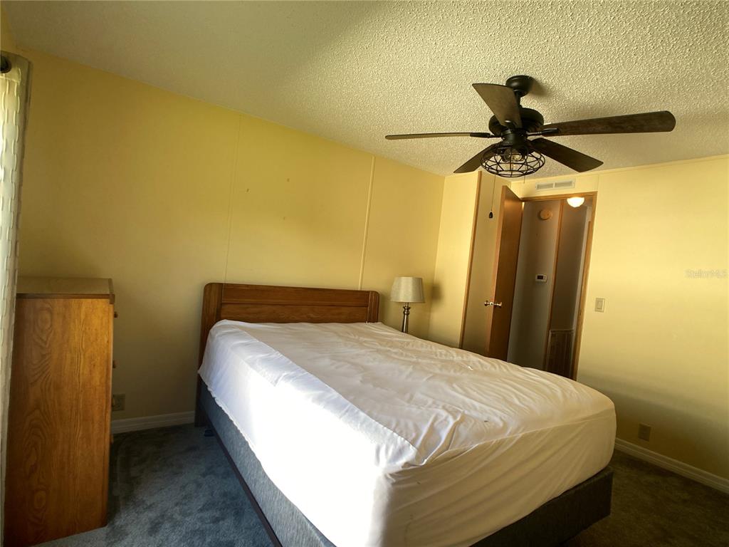 1710 7th Street Southwest, Unit 85 Ruskin, FL 33570 - Photo 19 of 28 a bedroom with a bed and a ceiling fan