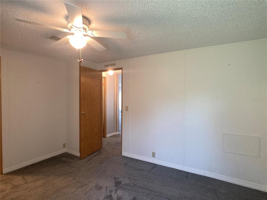 1710 7th Street Southwest, Unit 85 Ruskin, FL 33570 - Photo 20 of 28 an empty room with a chandelier fan and windows