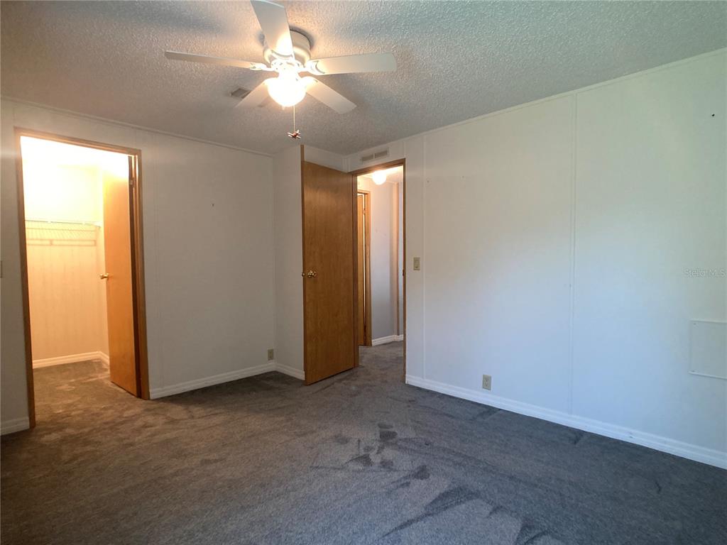 1710 7th Street Southwest, Unit 85 Ruskin, FL 33570 - Photo 22 of 28 an empty room with a chandelier fan and windows