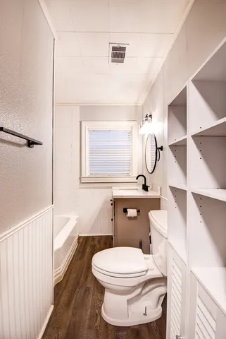 a bathroom with a toilet sink a mirror a vanity and shower