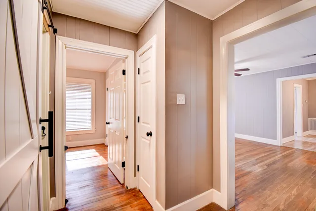 a view of a hallway with wooden floor and staircase