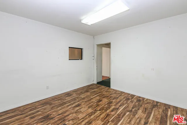 a view of a room with wooden floor and white walls