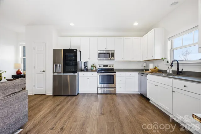 a kitchen with stainless steel appliances a refrigerator sink and microwave
