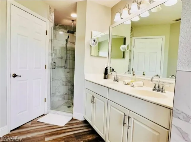 a bathroom with a double vanity sink mirror and shower