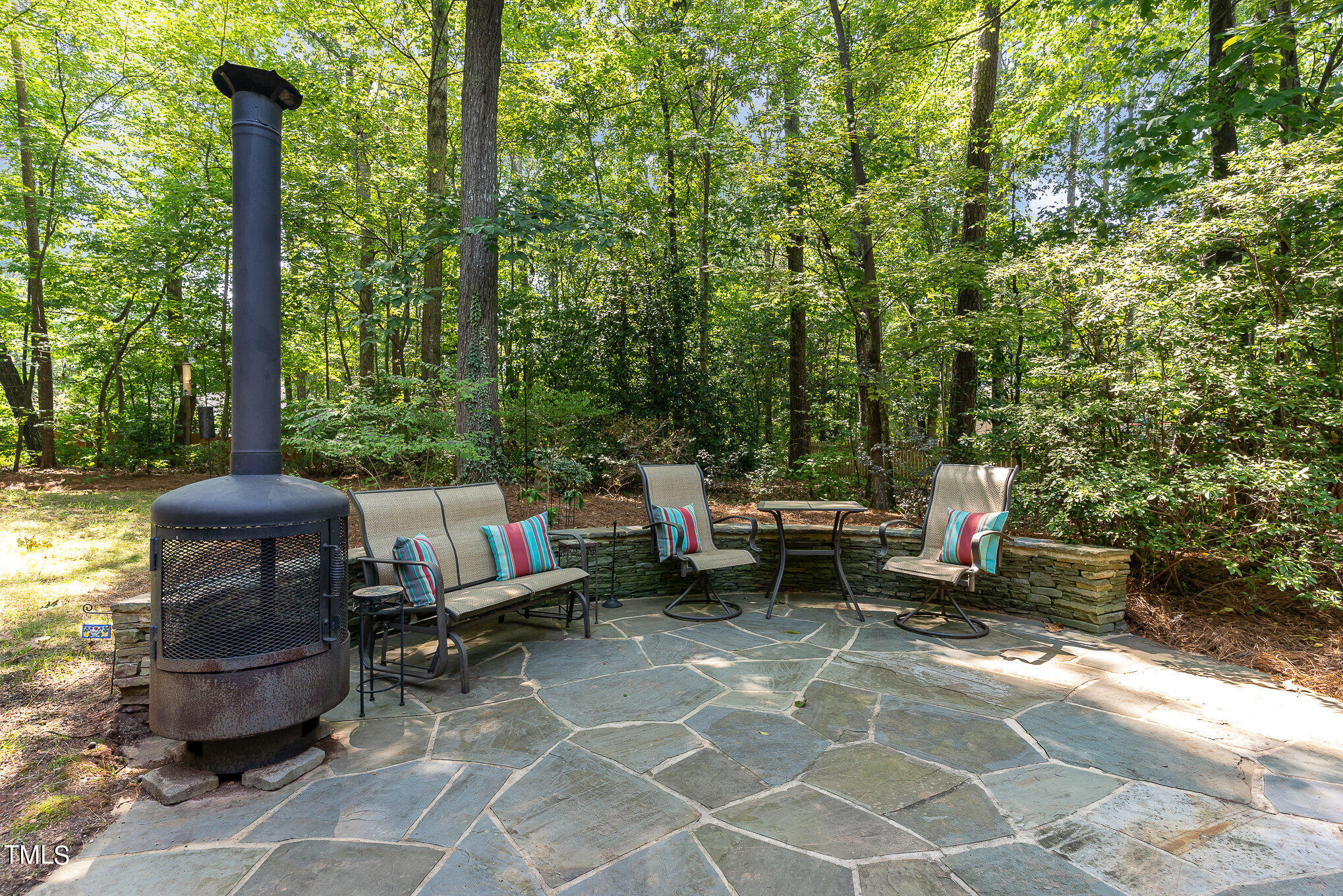 109 Lochfield Drive Cary, NC 27518 - Photo 28 of 43 a view of a patio with table and chairs potted plants and a palm tree