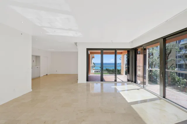 a view of an empty room with wooden floor and a floor to ceiling window