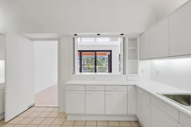 a view of an empty room with a cabinet and mirrors