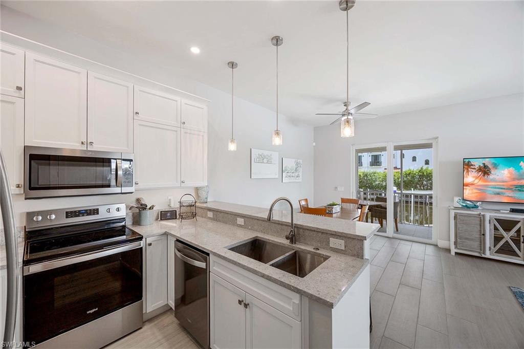 1395 Curlew Avenue, Unit 43 Naples, FL 34102 - Photo 7 of 24 a kitchen with stainless steel appliances a stove sink microwave and cabinets