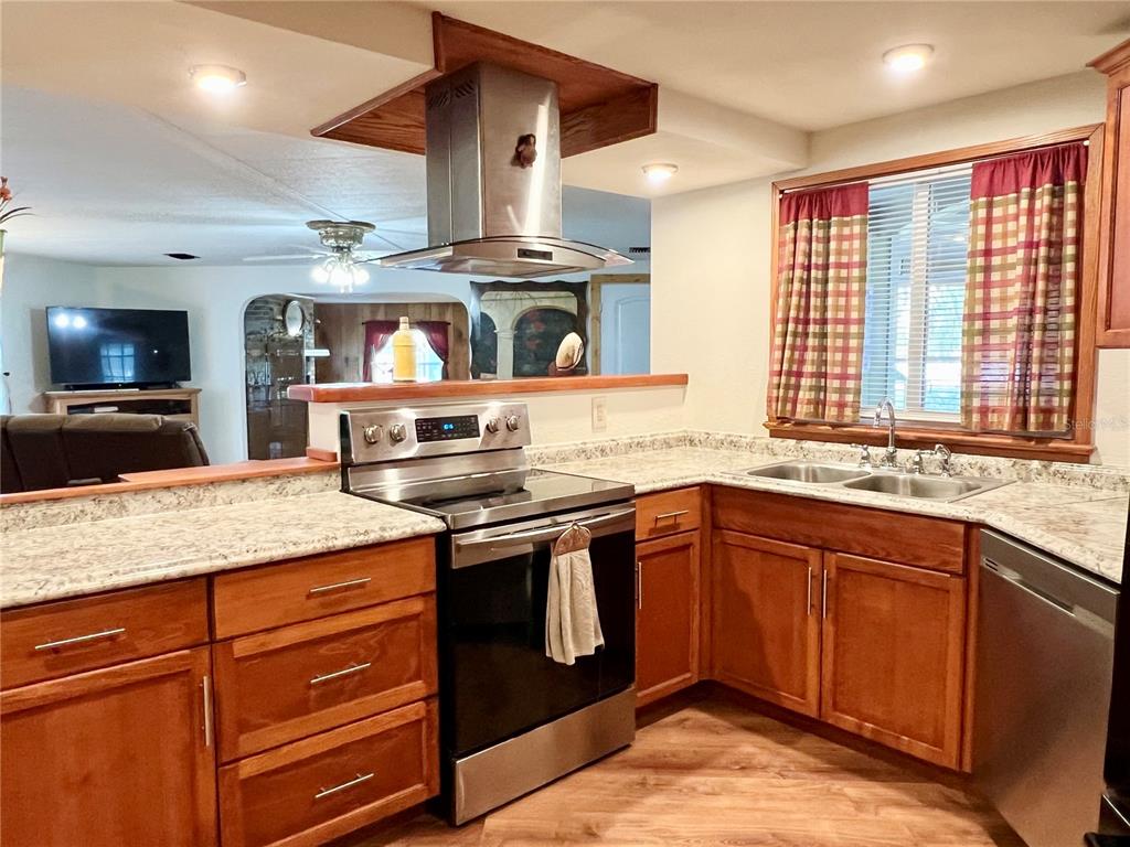 2 South Bobwhite Road Wildwood, FL 34785 - Photo 22 of 57 a kitchen with stainless steel appliances granite countertop a stove and a sink