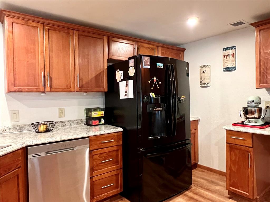 2 South Bobwhite Road Wildwood, FL 34785 - Photo 25 of 57 a kitchen with stainless steel appliances granite countertop a refrigerator and a stove top oven