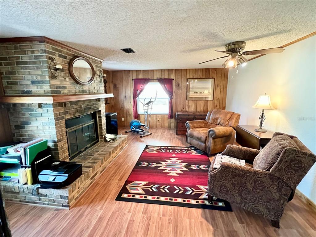 2 South Bobwhite Road Wildwood, FL 34785 - Photo 8 of 57 a living room with furniture a fireplace and a flat screen tv