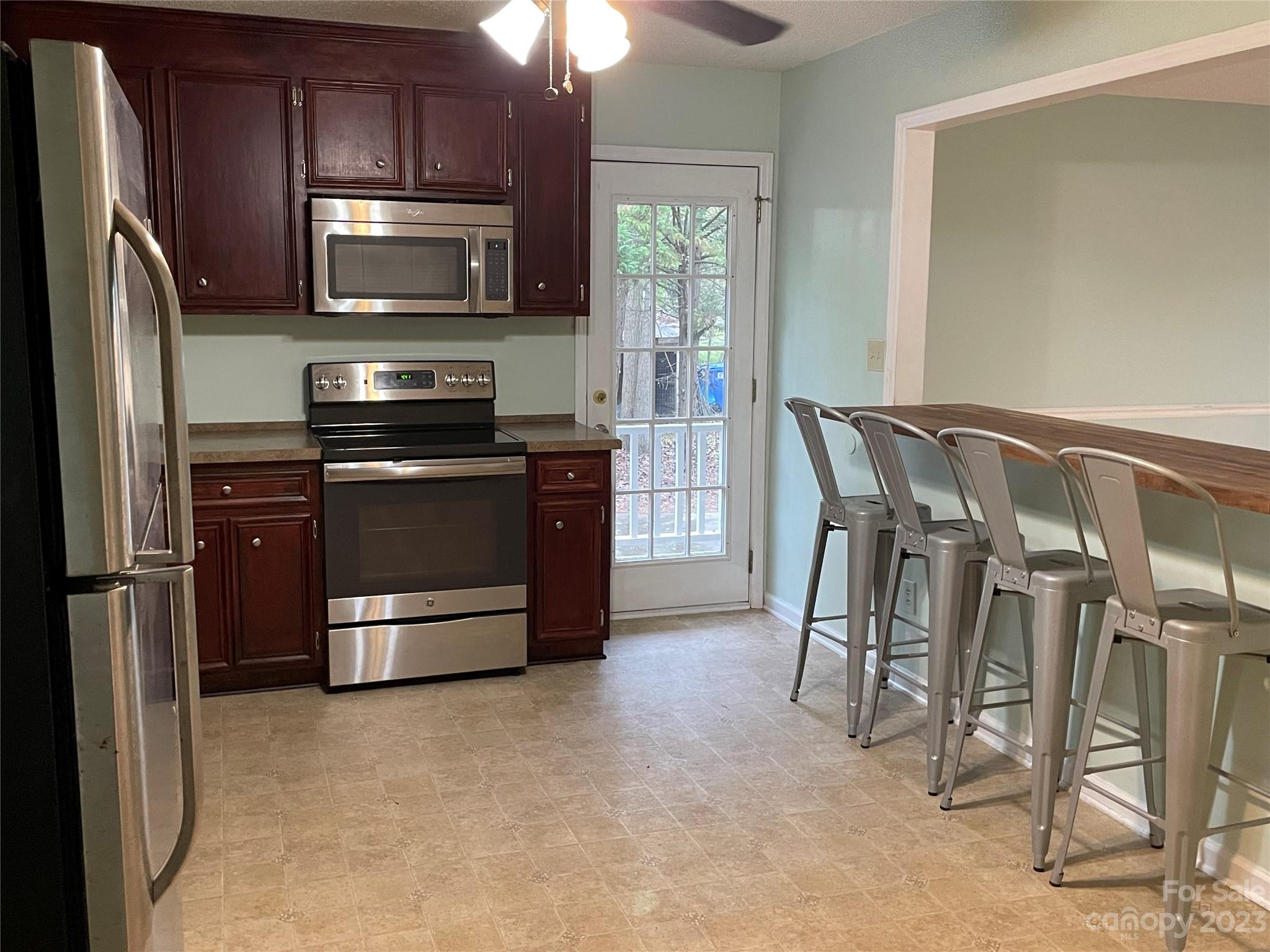 3885 Taxahaw Road Lancaster, SC 29720 - Photo 4 of 18 a kitchen with stainless steel appliances a stove a refrigerator and a fireplace