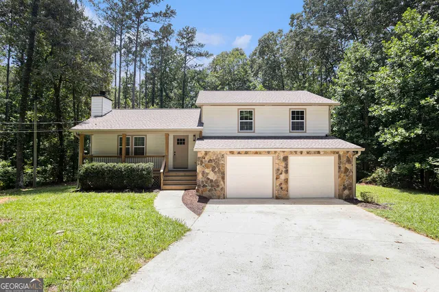 a front view of a house with a garden and yard
