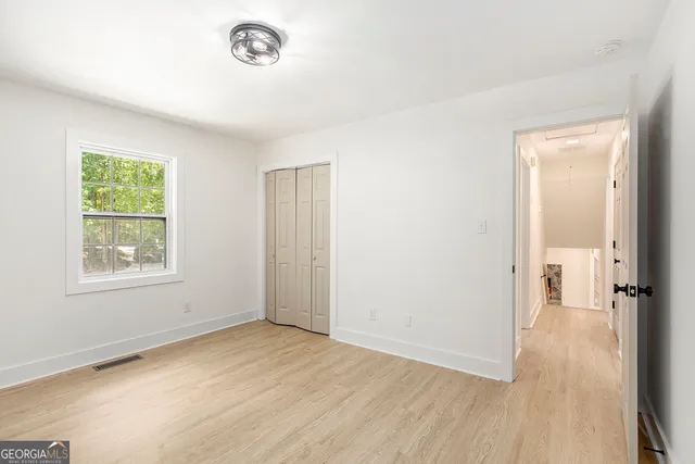 an empty room with wooden floor and a window