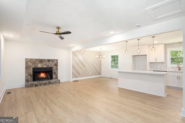 a view of an empty room with a fireplace and a window