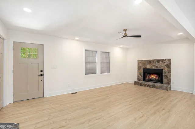 a view of an empty room with a fireplace and a window