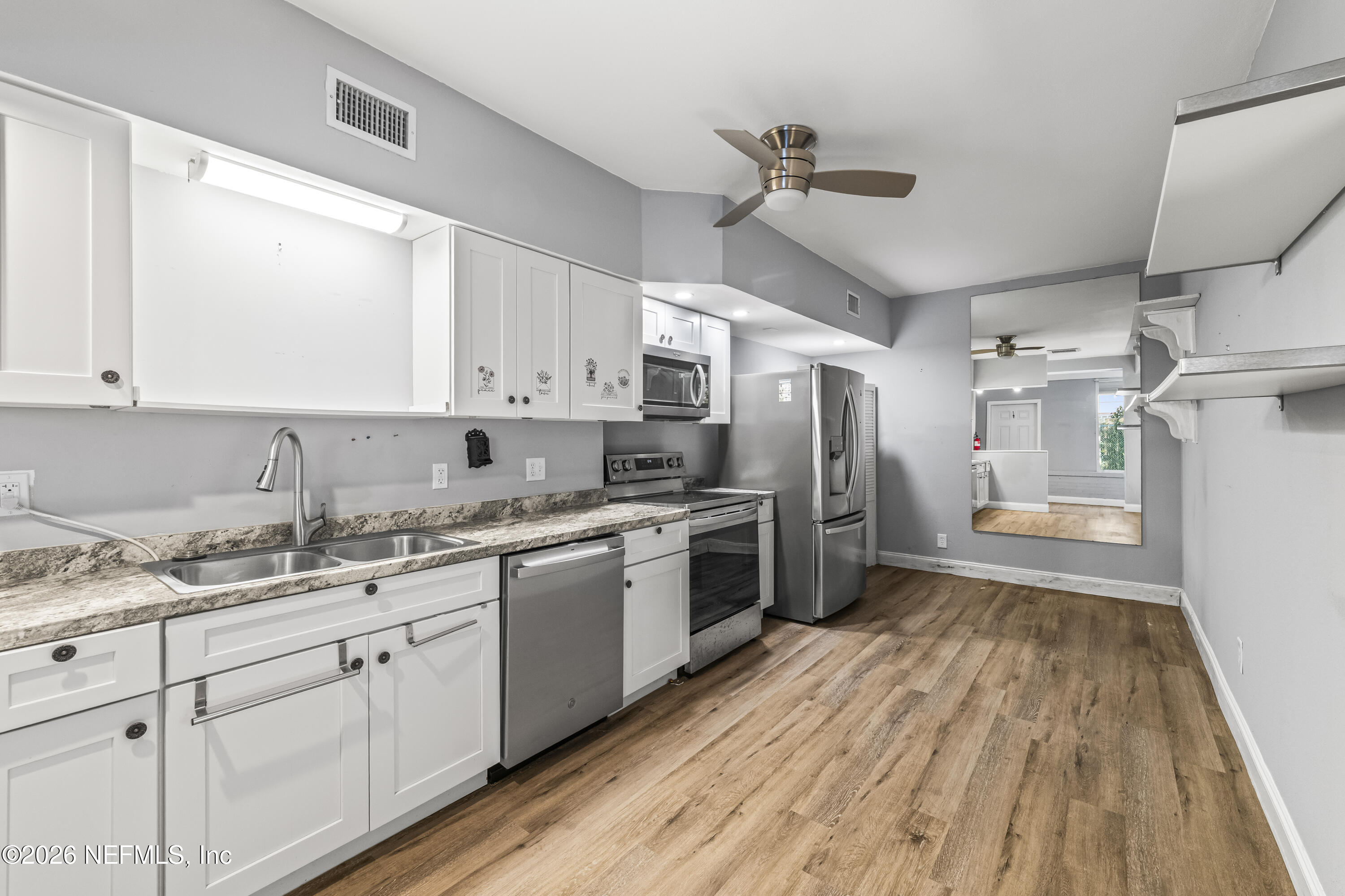 10612 Fort Caroline Road Jacksonville, FL 32225 - Photo 29 of 51 a kitchen with sink a refrigerator and cabinets