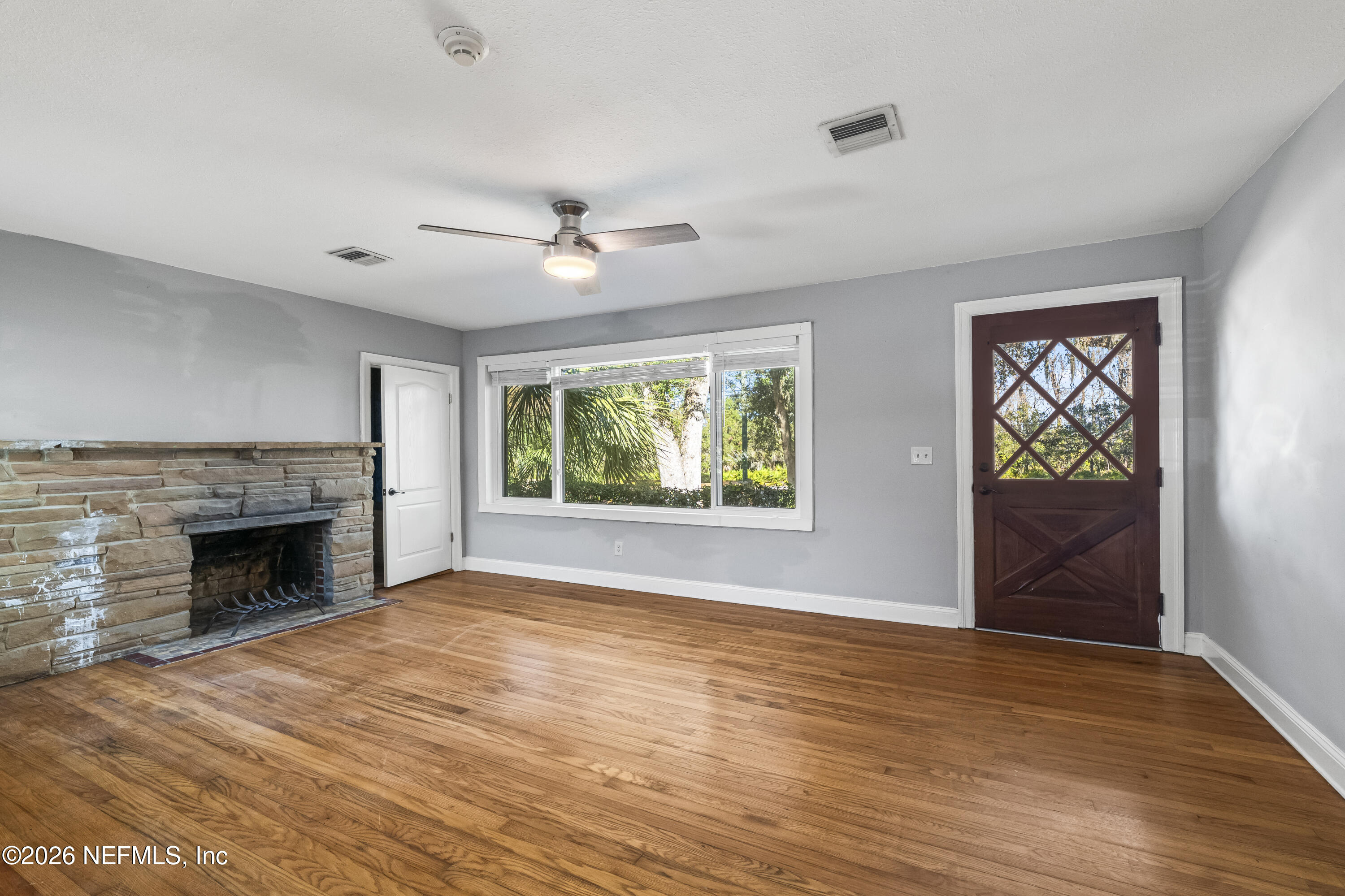 10612 Fort Caroline Road Jacksonville, FL 32225 - Photo 4 of 51 an empty room with windows fireplace and cabinet