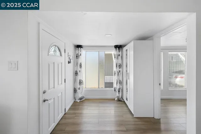 a view of a hallway with wooden floor and staircase