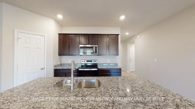 a kitchen with sink refrigerator and microwave