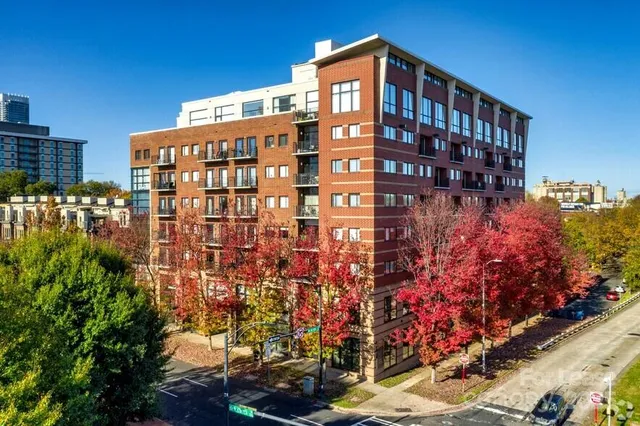 a kitchen with stainless steel appliances granite countertop a refrigerator a sink dishwasher a stove and white countertops with wooden floor