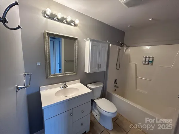 a bathroom with a sink a toilet a mirror and shower