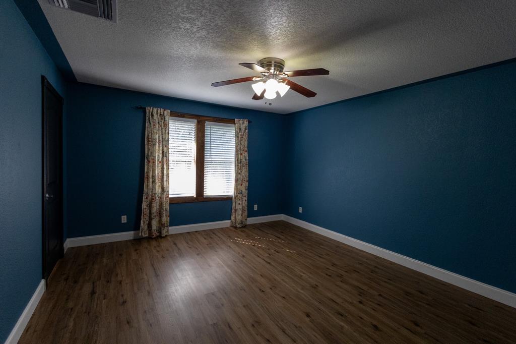 536 Cavin Lane Axtell, TX 76624 - Photo 24 of 40 an empty room with wooden floor chandelier fan and windows