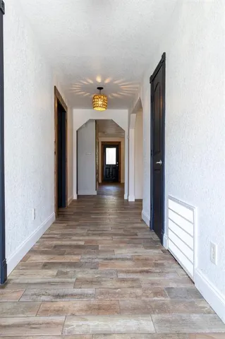 a view of a hallway with wooden floor and a fireplace