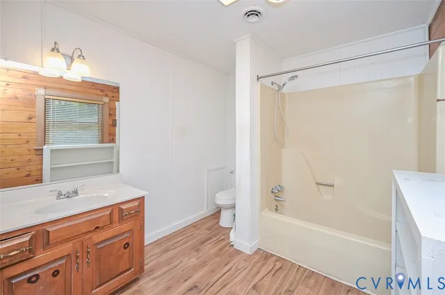 a bathroom with a granite countertop sink a toilet and shower