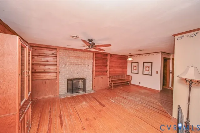 a view of empty room with a fireplace and wooden floor