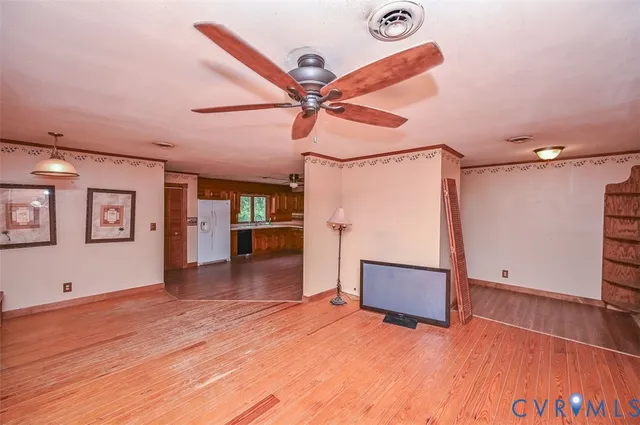 a view of a livingroom with wooden floor and a ceiling fan