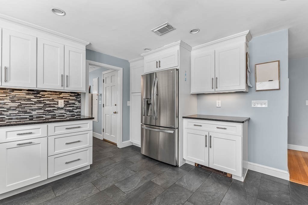18 Greensboro Road Dedham, MA 02026 - Photo 14 of 39 a kitchen with white cabinets and stainless steel appliances
